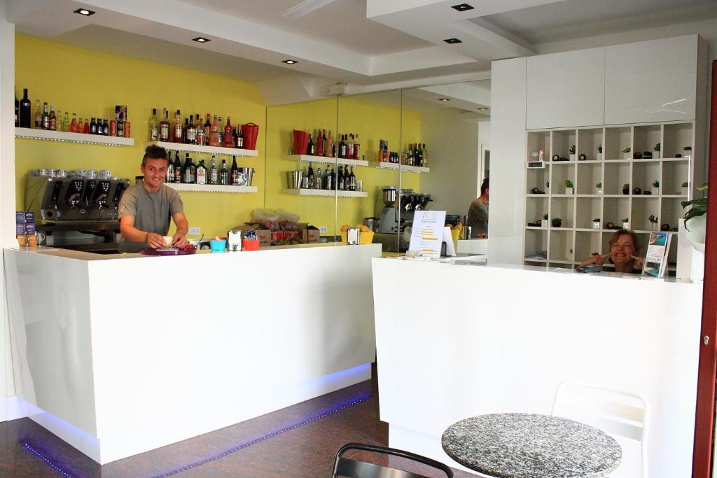 a man is standing behind a counter in a coffee shop at Hotel Lido Vieste in Vieste