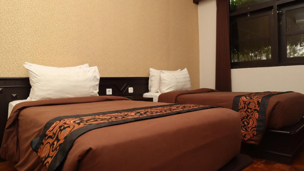 Postel nebo postele na pokoji v ubytování Kusuma Agrowisata Resort & Convention