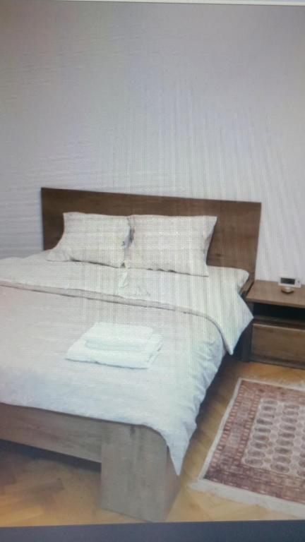 a bed with a wooden headboard with a white towel on it at Apartament Lavinia in Călimăneşti