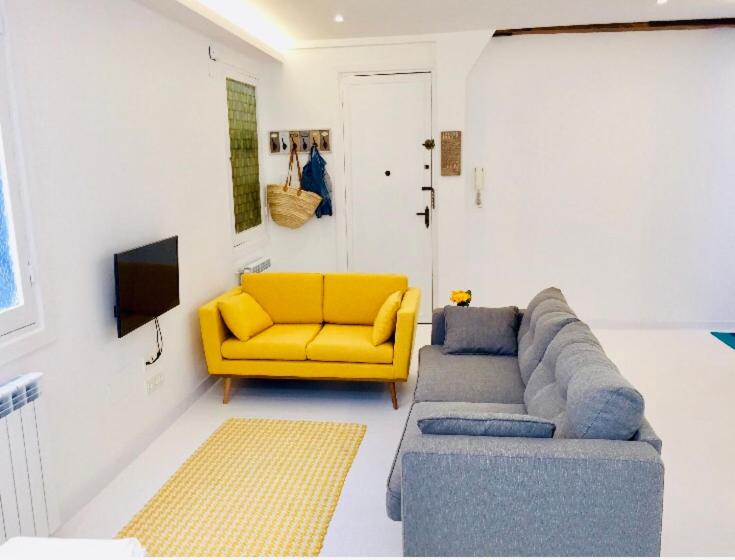 sala de estar con sofá y silla amarilla en Zurriola Beach, en San Sebastián