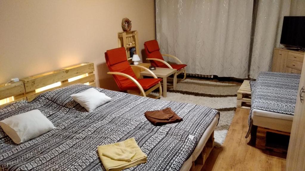 a bedroom with two beds and a table and chairs at Gesztenyés Apartman in Miskolc
