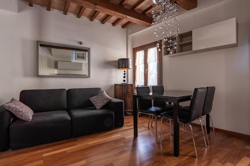 een woonkamer met een zwarte bank en een tafel bij Torretta Via della Viola Appartamento in Perugia