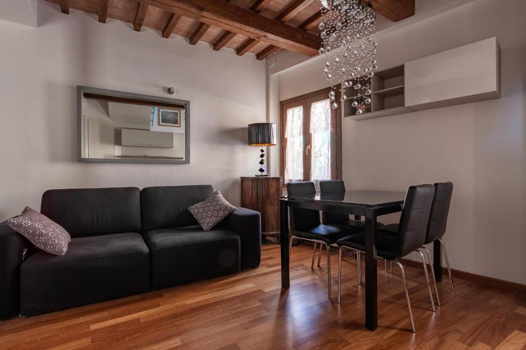 salon z czarną kanapą i stołem w obiekcie Torretta Via della Viola Appartamento w mieście Perugia