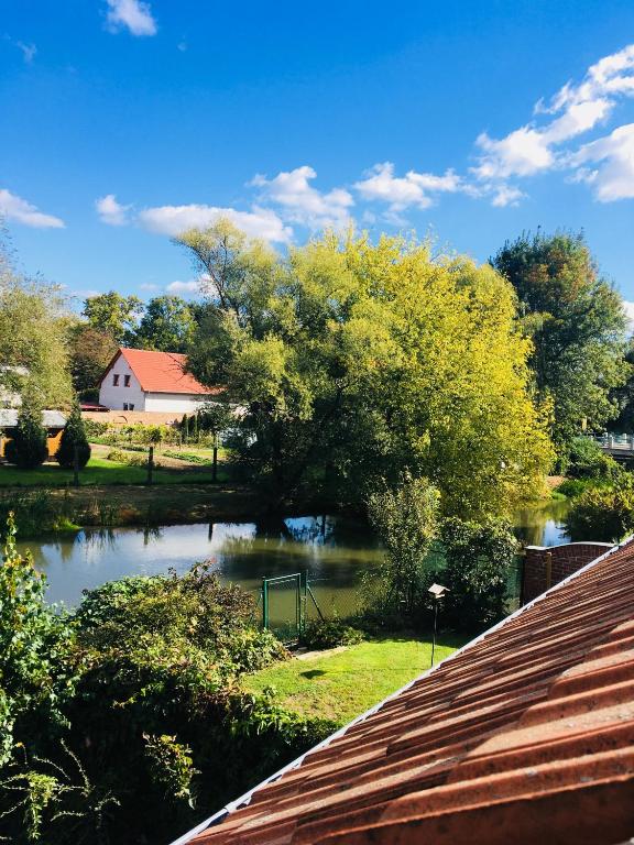 most nad rzeką z domem w tle w obiekcie Apartmán U ZÁMECKÉ DYJE w mieście Lednice