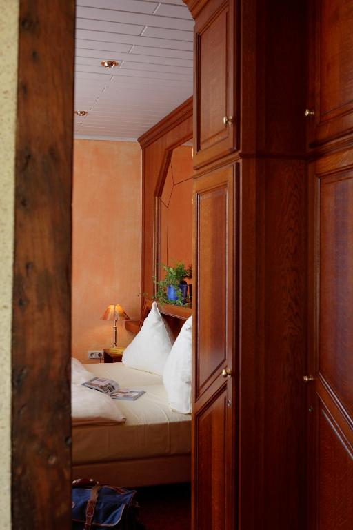 a bedroom with a bed in a room with a mirror at Logis Hotel-Restaurant Petry in Vianden