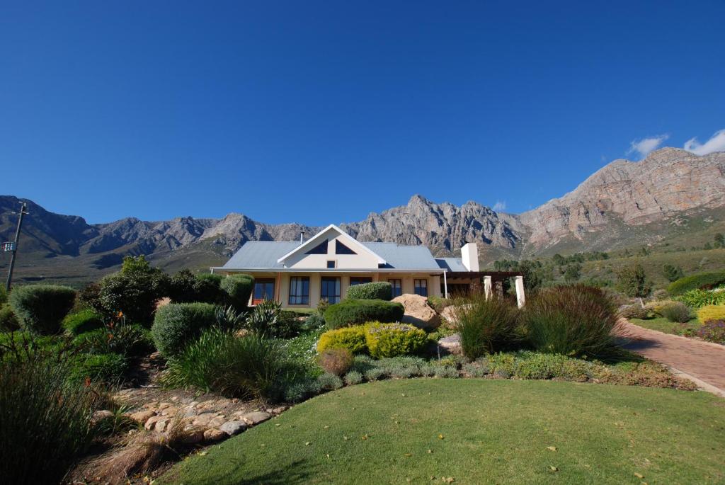 una casa con montagne sullo sfondo di Kingsbury Cottage a Breërivier