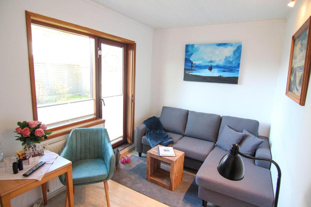 ein Wohnzimmer mit einem Sofa und 2 Stühlen in der Unterkunft Kapitänshaus Lassen - Zimmer Nes Pük in Westerland