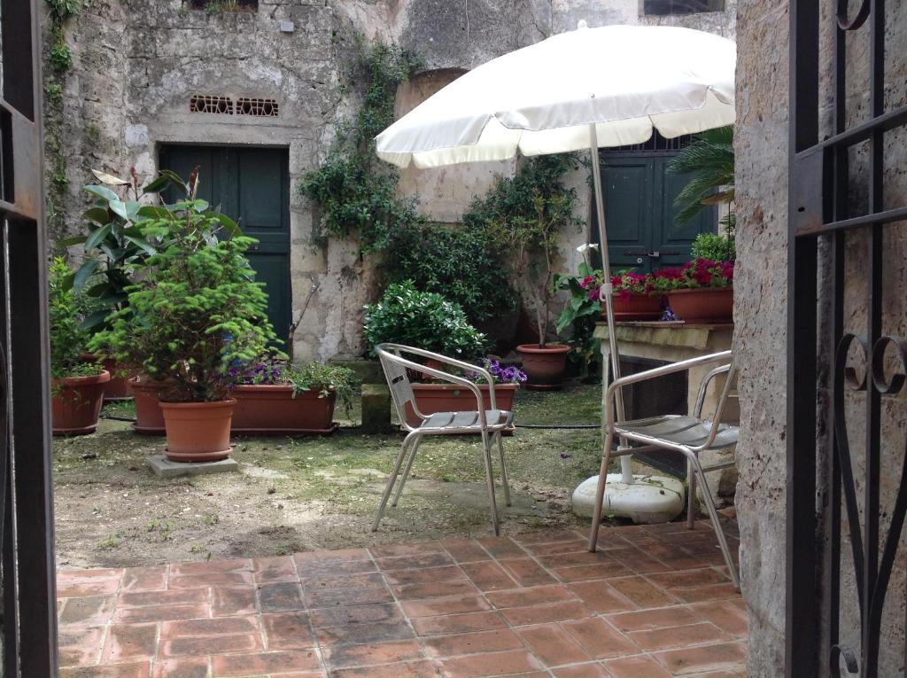 a patio with two chairs and an umbrella at A Casa di Irene in Matera