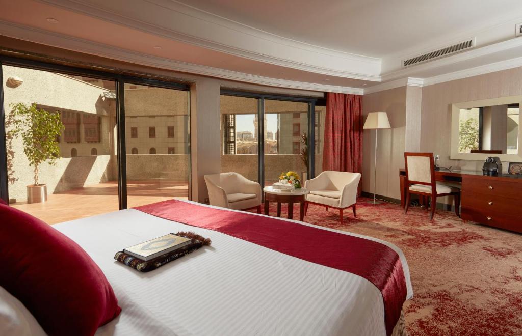 ein Hotelzimmer mit einem Bett, einem Schreibtisch und einem Zimmer in der Unterkunft Frontel Al Harithia Hotel in Medina
