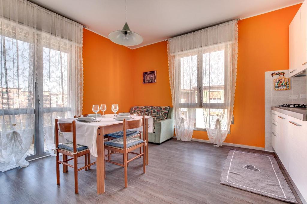 een eetkamer met oranje muren en een tafel en stoelen bij Smart Mestre centre in Mestre