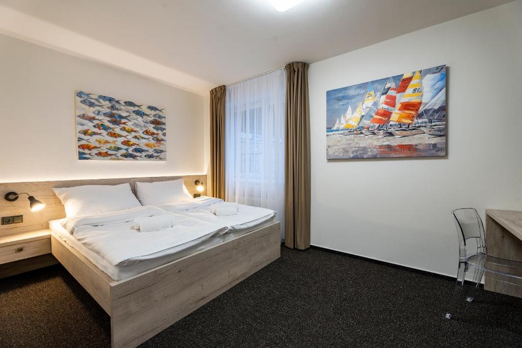 a bedroom with a bed and a painting on the wall at Penzion Pod Kartouzkou in Dolany