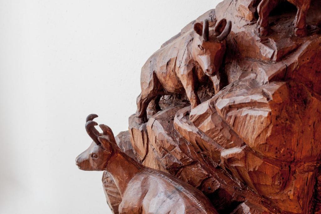 drewniany posąg zwierząt jeżdżących na koniu w obiekcie Nellali w mieście Gressan