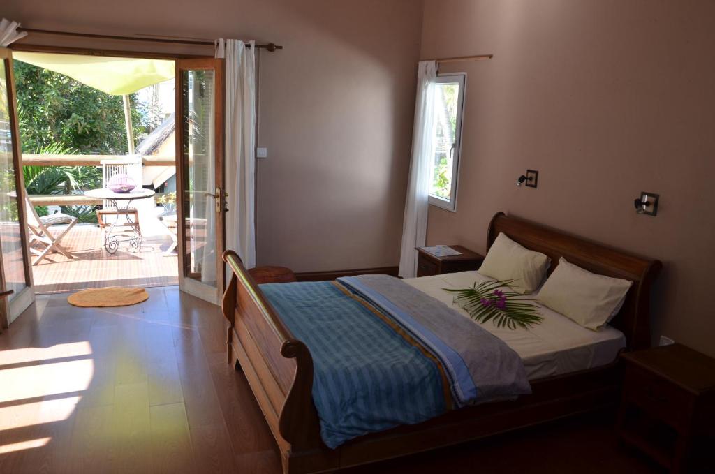 a bedroom with a bed and a door to a patio at serin du cap in Blue Bay