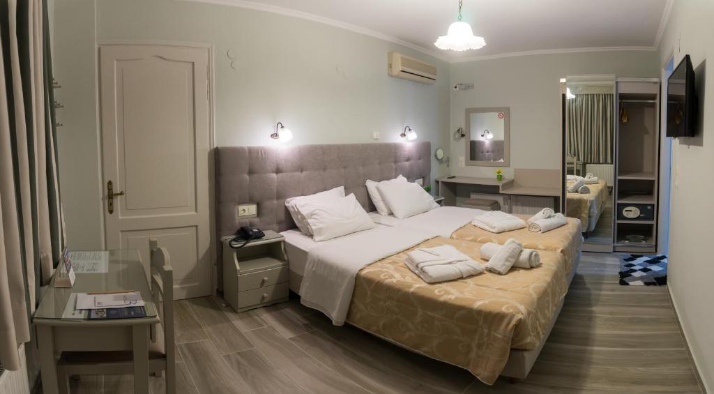 1 dormitorio con 2 camas con almohadas blancas en Aklidi Hotel, en Mytilini