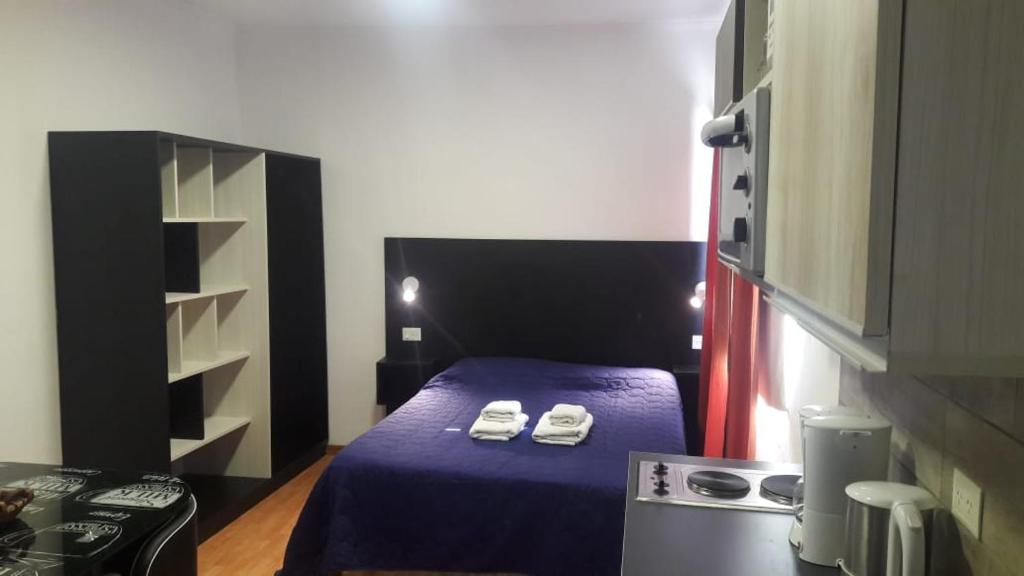 ein kleines Zimmer mit einem Bett mit Schuhen drauf in der Unterkunft Departamento Estudio 2 in Neuquén