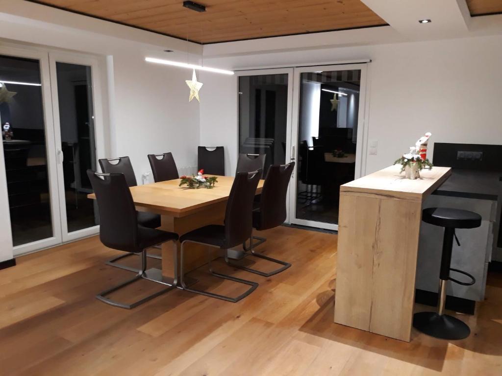 a dining room with a wooden table and chairs at La maison des savoyards in Husseren-Wesserling
