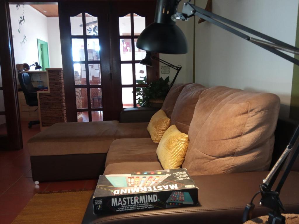 a living room with a couch and a book on a table at Hostel Nature in Zambujeira do Mar