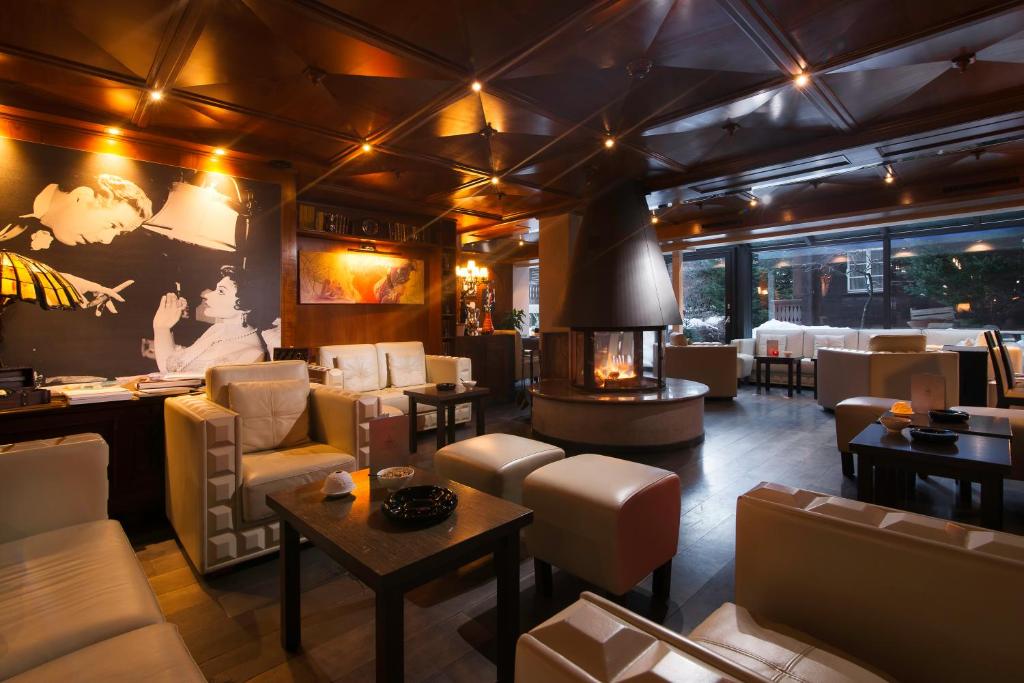 a restaurant with couches and tables and a fireplace at Boutique Hotel Albana Real - Restaurants & Spa in Zermatt