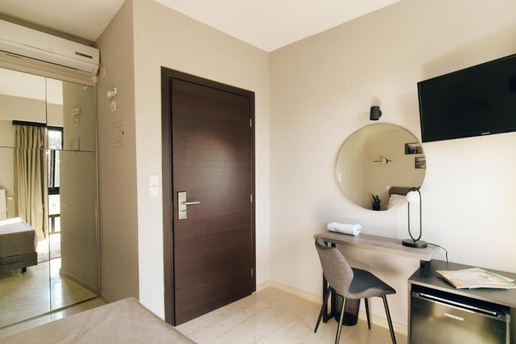 雅典Athens Iris Hotel的客房设有书桌、镜子和门