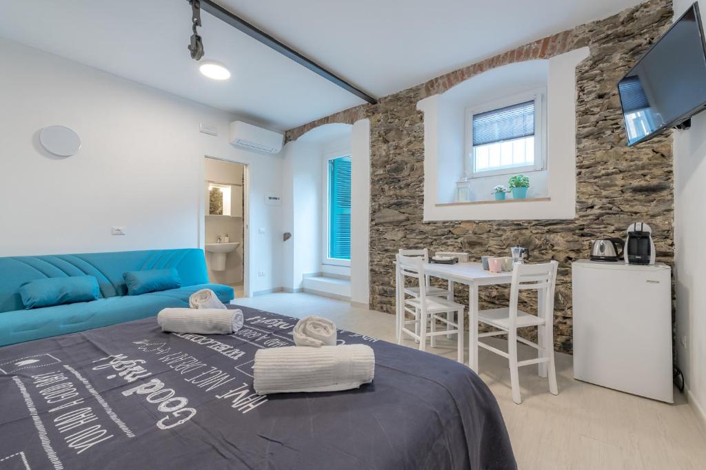 a room with a blue bed and a table with chairs at Il Giardino di Riomaggiore Suite in Riomaggiore