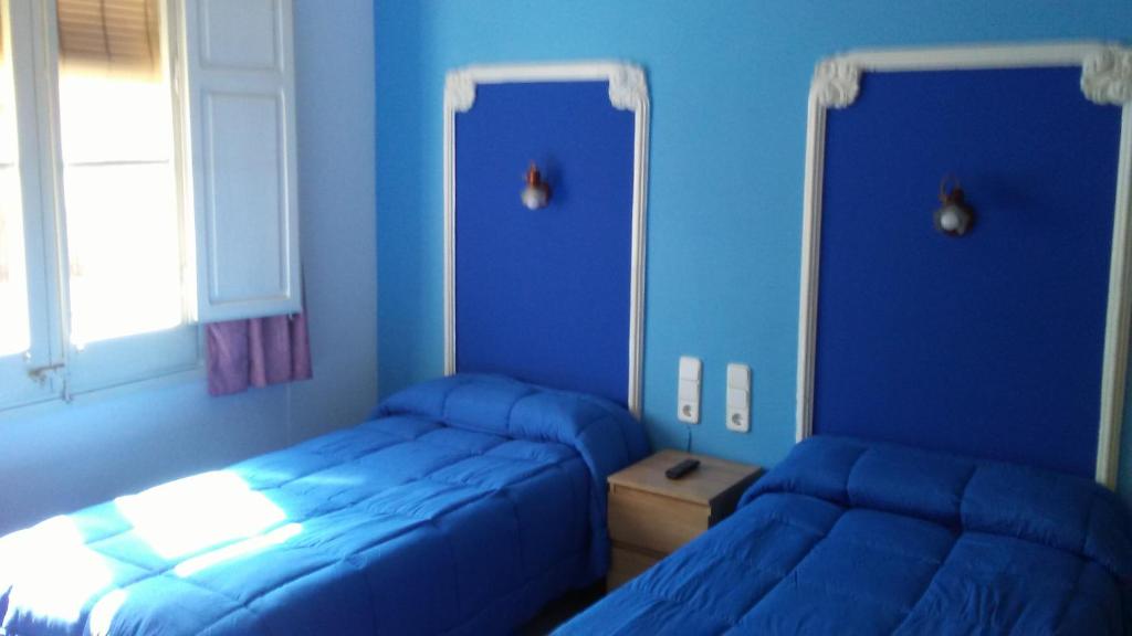 Un pat sau paturi într-o cameră la Hostal Porta de Ferro