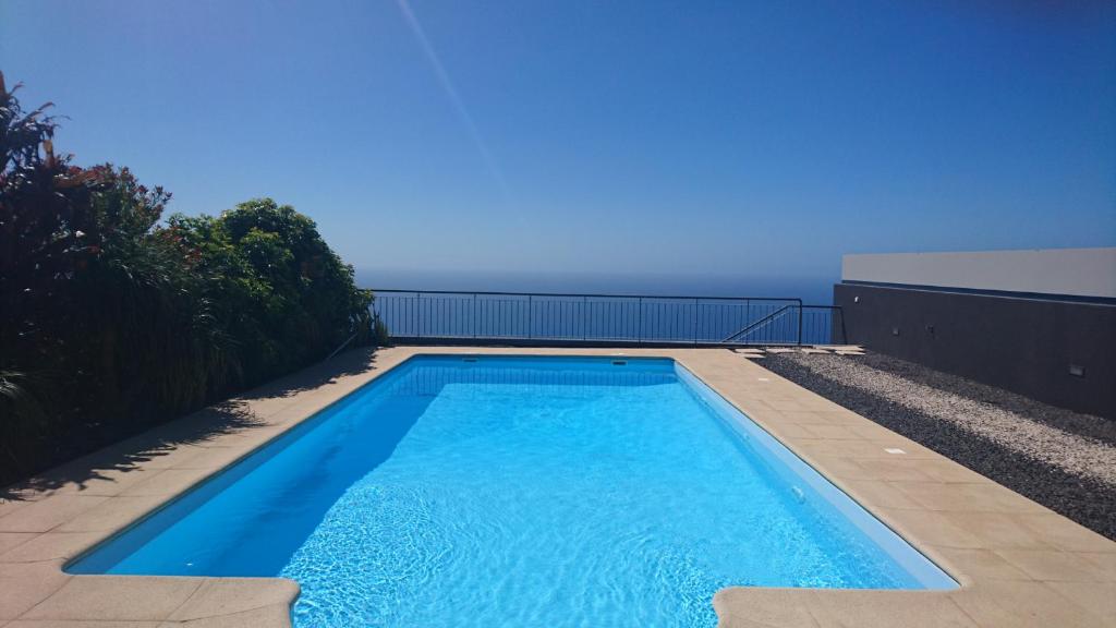 una piscina sul lato di una casa di Loreto Luxury ad Arco da Calheta