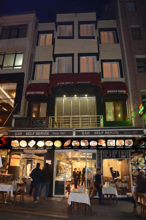 a store with tables and chairs in front of a building at Şar Pansiyon in Istanbul