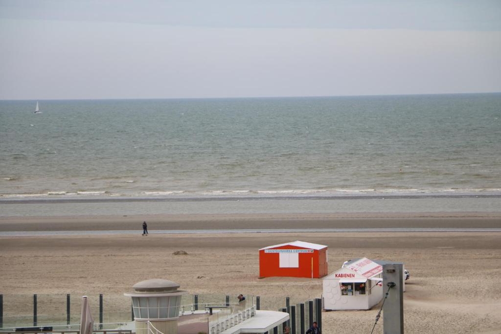 una spiaggia con un edificio rosso sulla spiaggia di Noble dune a Oostduinkerke