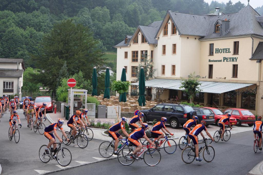 a group of people riding bikes down a street at Logis Hotel-Restaurant Petry in Vianden