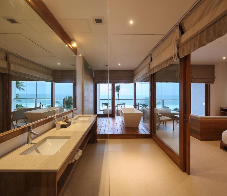 a bathroom with two sinks and a large mirror at Riff Hikkaduwa in Hikkaduwa