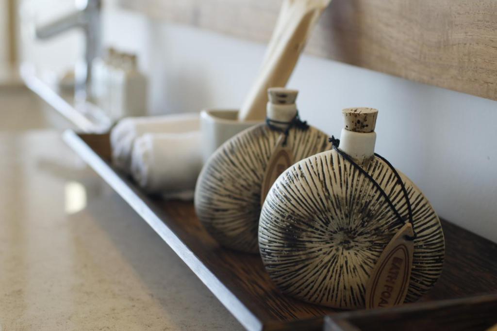 two vases are sitting on a wooden shelf at Riff Hikkaduwa in Hikkaduwa