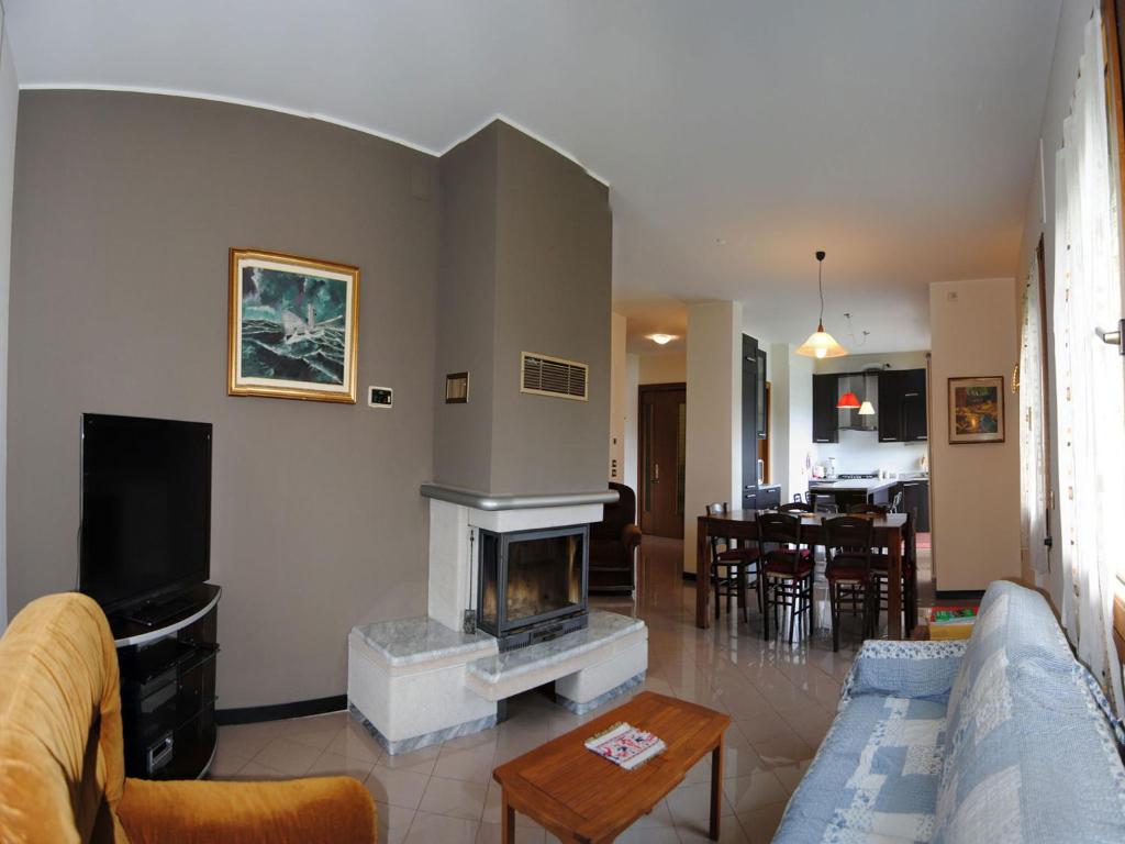 sala de estar con sofá y chimenea en Appartamenti Vacanza Tra Venezia e le Dolomiti, en Vittorio Veneto
