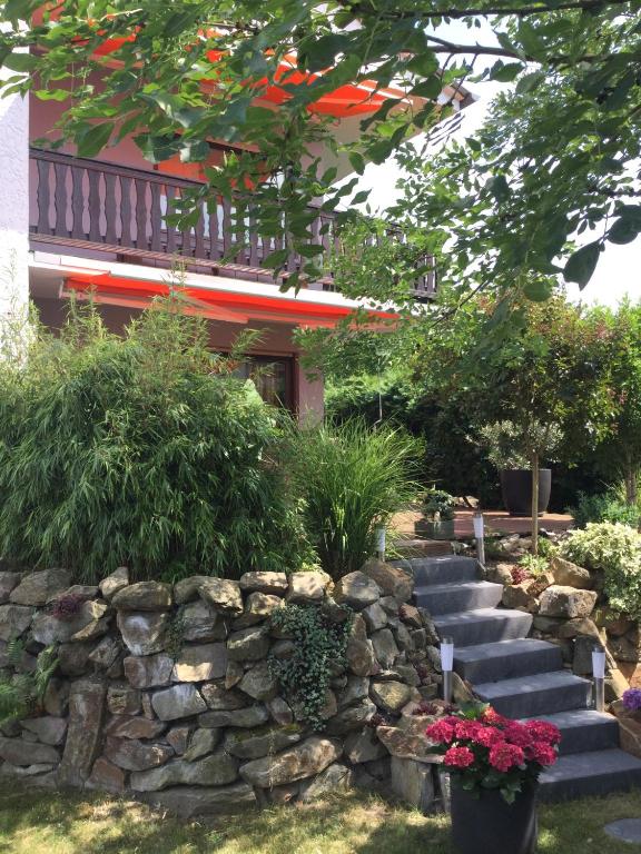 Un jardín con escaleras y un muro de piedra y flores. en Ferienwohnung Esmeralda, en Oppenheim