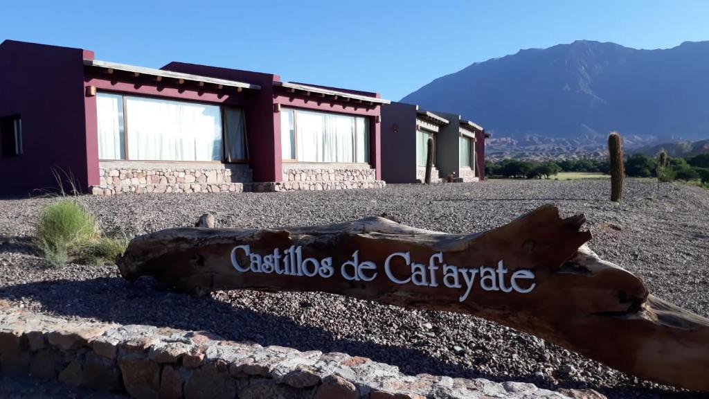 a log sitting on the ground in front of a building at Hotel Castillos de Cafayate in Cafayate
