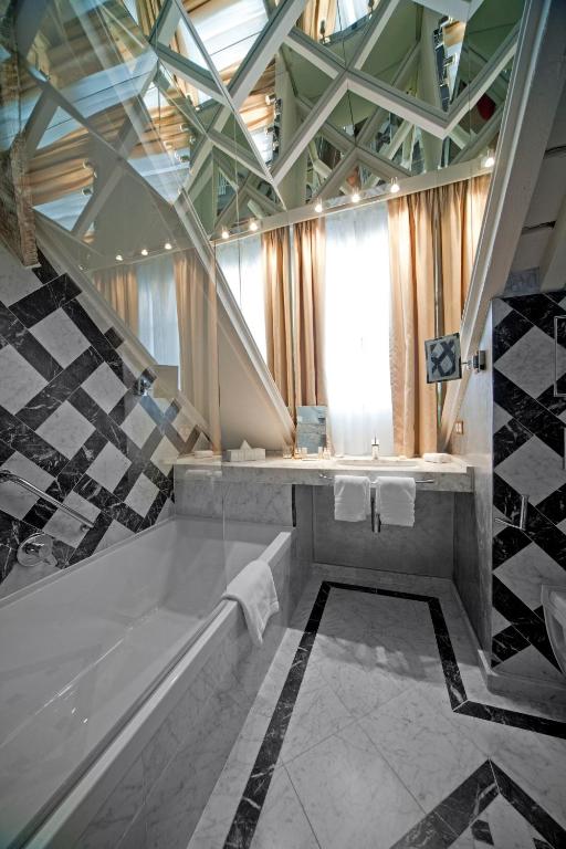 a large bathroom with a tub and a sink at Hotel Le Place d'Armes - Relais & Châteaux in Luxembourg