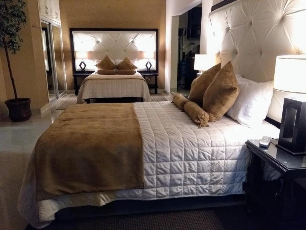 ein großes Schlafzimmer mit 2 Betten mit Kissen darauf in der Unterkunft Hermoso Depto por UACH II Con Terraza y linda vista in Chihuahua
