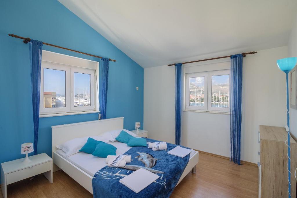 a blue bedroom with a bed with a cat on it at Apartments Mirjana in Trogir