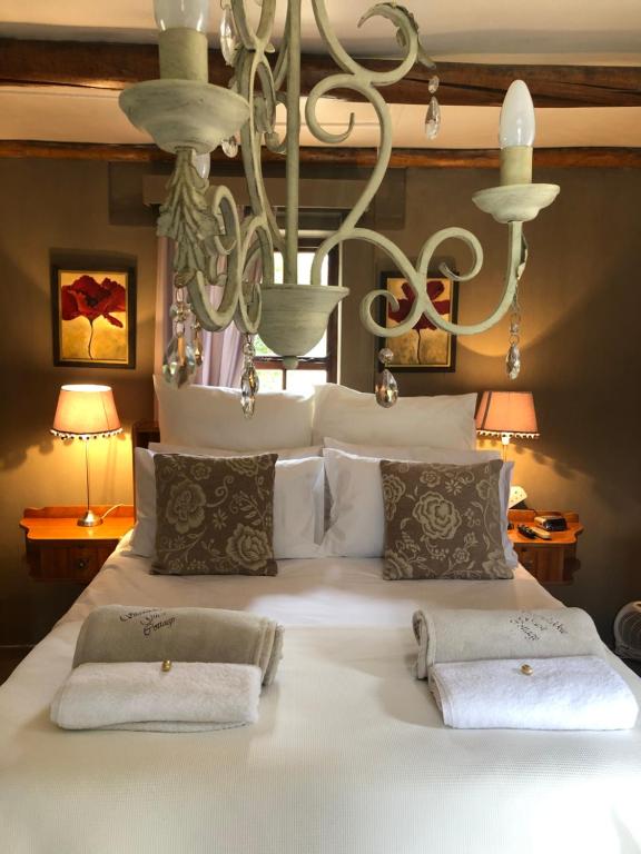 a large white bed with two pillows on it at Staandakkie Guest Cottage in Bredasdorp