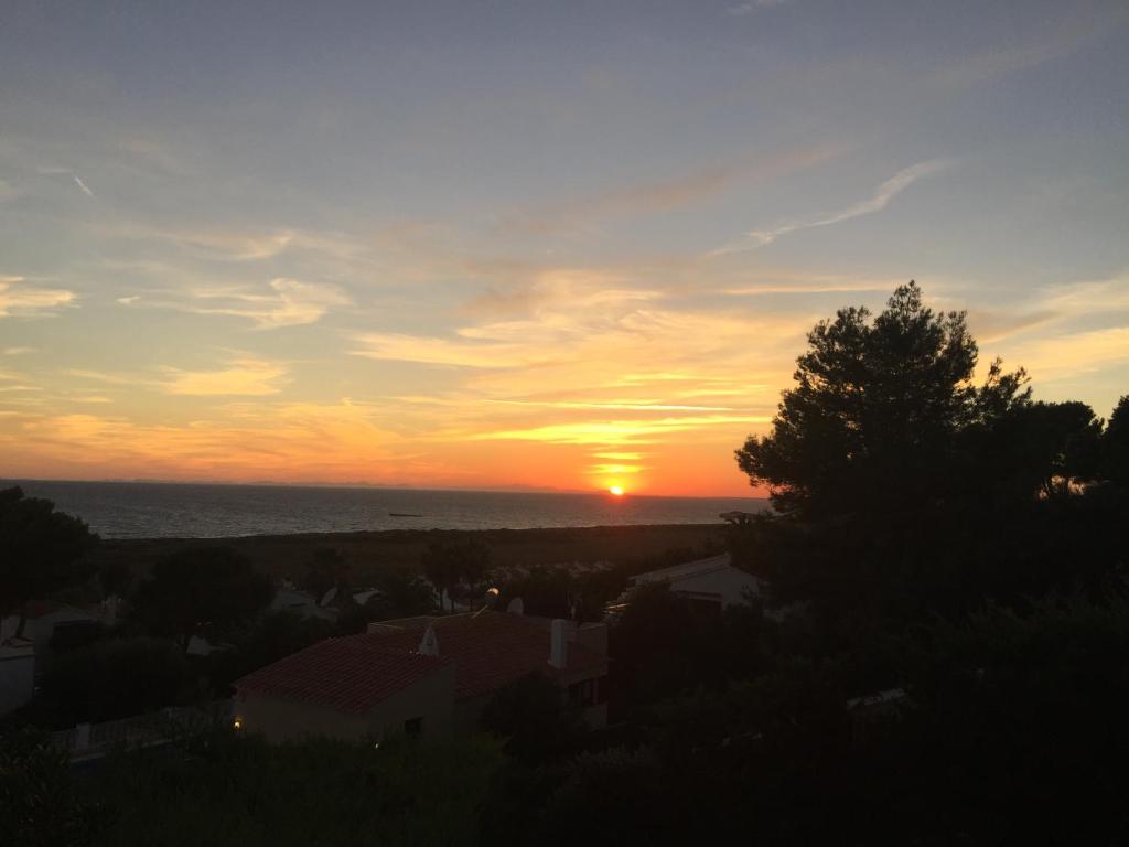 einen Sonnenuntergang mit Sonnenuntergang über dem Meer in der Unterkunft Villa PANORAMA y Villa MIRADOR in Son Bou