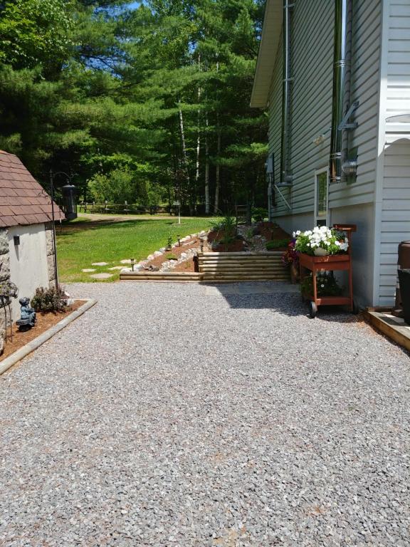 a gravel driveway next to a house at Suite in the Bush-Private Apartment in Bancroft