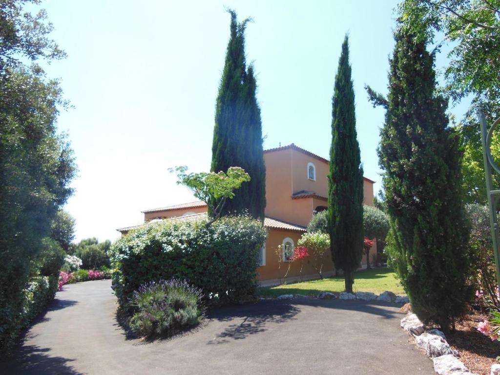 une maison avec des arbres en face d'une allée. dans l'établissement Villa F5-Wifi-piscine Saint Gely du Fesc, à Saint-Gély-du-Fesc