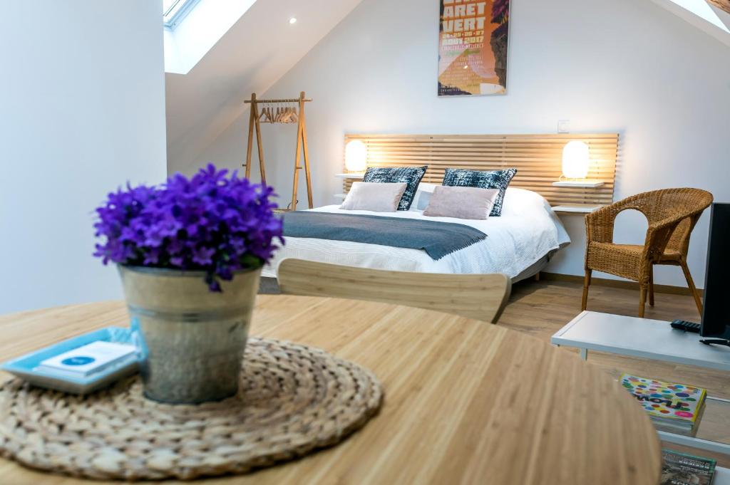 a bedroom with a bed with purple flowers on a table at B&B Charlestown in Charleville-Mézières