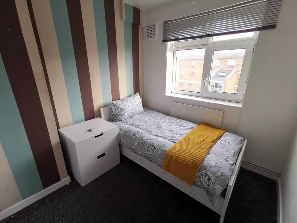 a small bedroom with a bed and a window at London budget Maisonette in London