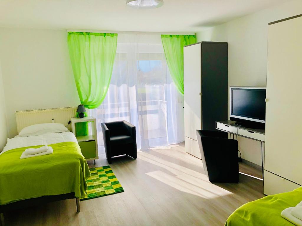 um quarto com uma cama verde e uma televisão em Zimmervermietung38 - Mammut 1 em Salzgitter