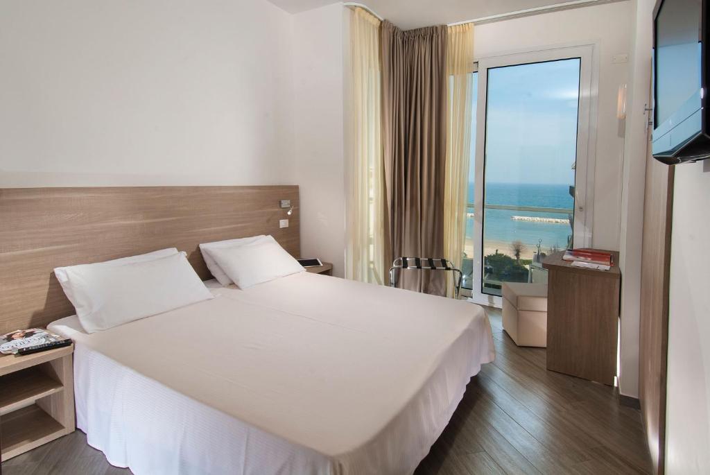 a hotel room with a bed and a large window at Hotel Atlantic & Spa in Gabicce Mare