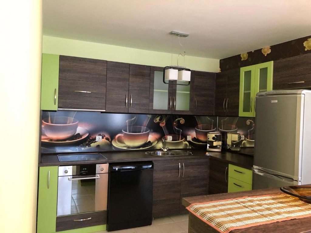 a kitchen with wooden cabinets and appliances with pots and pans at GALA APARTMENT in Veliko Tŭrnovo