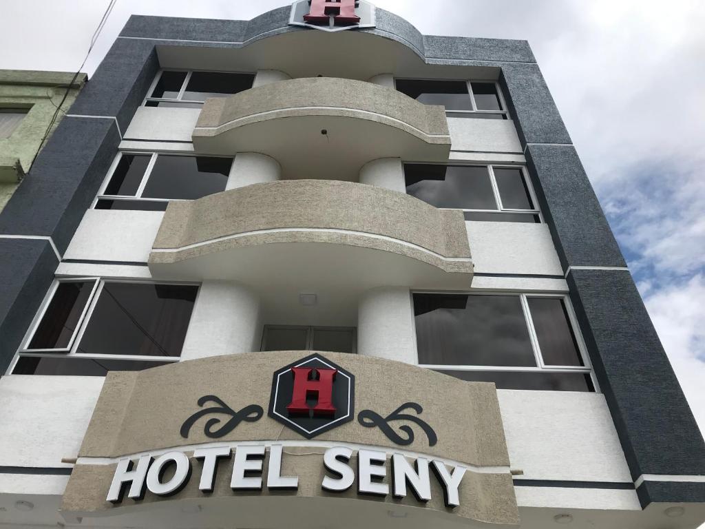 un cartello di sentinella dell'hotel sul lato di un edificio di Hotel Seny ad Ambato