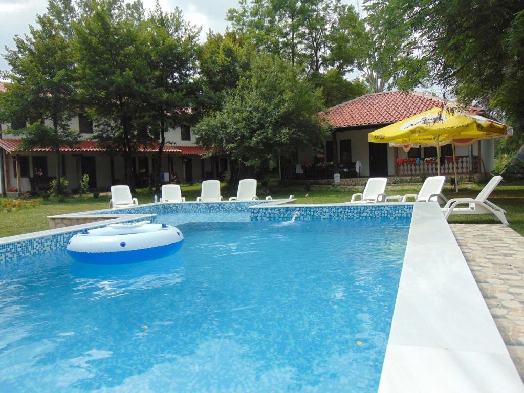 a swimming pool with chairs and an umbrella at Holiday Park Ranchoto in Kirkovo