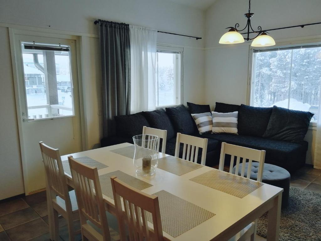 a living room with a table and chairs and a couch at Leviraitti 4 A2 in Kittilä