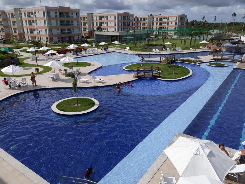 een groot zwembad met blauw water in een resort bij Porto de Galinhas - Muro Alto Condomínio Clube in Porto De Galinhas